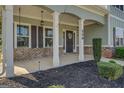 Spacious covered front porch with white columns, dark shutters, and a welcoming wreath on the front door at 509 Cowpens Rd, Social Circle, GA 30025