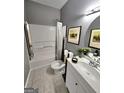 Cozy bathroom with framed wall art, neutral colors, and a shower-tub combination at 530 Shadowmoore Dr, Riverdale, GA 30274