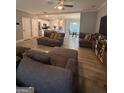 Spacious living room with wood flooring, lots of seating and open to dining and kitchen at 7703 Fawn Cir, Covington, GA 30014