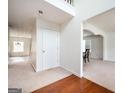 Bright foyer with hardwood floors and carpeted hallway leading to other areas of the house at 347 Cobblestone Ct, Hampton, GA 30228
