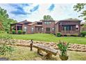 Spacious backyard with green lawn, stone bench, and manicured landscaping at 4 & 5 Northlake Cir, Peachtree City, GA 30269