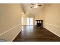 Spacious living room featuring dark wood-look flooring, ceiling fan, and a fireplace for a warm ambiance at 710 Thomasville Se Blvd, Atlanta, GA 30315