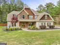 Inviting two-story home with stone and shingle accents, beautiful landscaping, and a welcoming entrance at 100 Chantilly Ln, Fayetteville, GA 30215