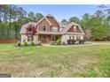 Charming two-story home featuring stone and shingle accents, manicured landscaping, and an inviting walkway at 100 Chantilly Ln, Fayetteville, GA 30215