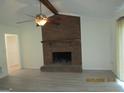 Cozy living room featuring a brick fireplace, ceiling fan, and light vinyl floors at 1611 Cherry Hill Sw Ct, Conyers, GA 30094