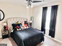 This cute bedroom features a neutral color scheme, a plush bed with stuffed animals and dark curtains at 3353 Medina Dr, Jonesboro, GA 30236