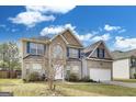 Charming two-story home with brick facade, blue shutters, and well-manicured landscaping at 540 Hamlet Dr, Hampton, GA 30228