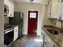 Bright kitchen with stainless steel appliances, granite counters, and updated flooring at 4941 Old Atlanta Rd, Hampton, GA 30228