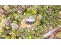 Aerial view of a secluded property with a home, shed, and above ground pool surrounded by dense trees at 575 Chuli Rd, Locust Grove, GA 30248