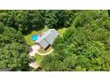 Aerial view of property surrounded by mature trees, featuring an inviting in-ground pool at 575 Chuli Rd, Locust Grove, GA 30248