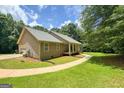 Beautiful house with an attached garage and a lush green lawn on a sunny day at 575 Chuli Rd, Locust Grove, GA 30248