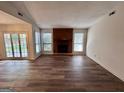 Spacious living room featuring a cozy fireplace, large windows, and elegant hardwood floors at 116 Glendale Dr, Peachtree City, GA 30269