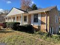 Brick house featuring a covered front porch supported by columns, and manicured landscaping at 6099 Winview Dr, Forest Park, GA 30297