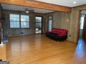 Open living room with hardwood floors, paneled walls, and a view of the front yard at 6099 Winview Dr, Forest Park, GA 30297