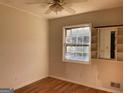 Bedroom featuring hardwood floors, a window, built-in shelves, and a ceiling fan at 6332 Valley Dale Dr, Riverdale, GA 30274