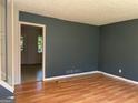 Living room featuring hardwood floors, neutral walls, and a glimpse into the adjacent room at 6332 Valley Dale Dr, Riverdale, GA 30274