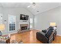 Bright living room features a vaulted ceiling, brick fireplace, and gleaming hardwood floors at 4654 Liberty Square Dr, Acworth, GA 30101