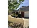 Brick home with a well-maintained lawn, mature landscaping, and a spacious driveway leading to a garage at 9039 River Bend Ct, Villa Rica, GA 30180