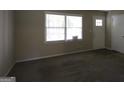 Bright living area featuring neutral carpeting, a large window, and fresh paint, creating a welcoming space at 767 San Miguel Dr, Stone Mountain, GA 30083