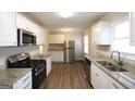 Updated kitchen with stainless steel appliances, granite countertops, and white cabinets at 756 Sugar Hill Ln, Conyers, GA 30094