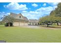 Spacious three-car garage with ample driveway space and a well-maintained lawn, perfect for car enthusiasts at 676 Mcbride Rd, Fayetteville, GA 30215