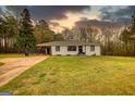 Charming home featuring white brick, black trim, lovely lawn, and covered parking at 1910 Reese Rd, Rutledge, GA 30663