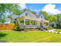 Picture perfect home with a cozy front porch, complemented by vibrant greenery and a well-manicured lawn at 2173 Conyers Se St, Covington, GA 30014