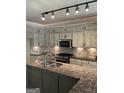 Well-lit kitchen features granite counters, stainless appliances, tile backsplash, a large island and custom cabinets at 1081 Bridge Mill Ave, Canton, GA 30114