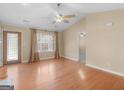 Bright living room featuring hardwood floors, a ceiling fan, and large windows offering lots of natural light at 1190 N Ola Rd, Mcdonough, GA 30252
