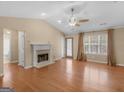 Spacious living room boasting a fireplace, hardwood floors, large windows, and a ceiling fan at 1190 N Ola Rd, Mcdonough, GA 30252