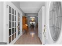Inviting foyer view with white trim, glass french doors, chandelier, and an arched entryway to the dining area at 90 Hazelridge Ln, Sharpsburg, GA 30277