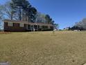 Traditional brick home featuring a well-maintained lawn and inviting front porch at 222 Farmbrook Pkwy, Stockbridge, GA 30281