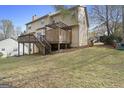 Expansive backyard with a wooden deck, stairs, and mature trees, providing a private outdoor space at 1475 Keystone Dr, Suwanee, GA 30024