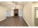 Bright living room featuring a cozy brick fireplace, wood flooring, and a ceiling fan at 596 Carlton Rd, Palmetto, GA 30268