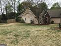 View of the yard featuring tan siding, mature trees, and a wooden fence at 3221 Rock Creek Dr, Rex, GA 30273