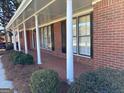 Inviting brick home featuring a covered porch with decorative columns and freshly manicured landscaping at 2533 Whispering Pines Dr, Grayson, GA 30017