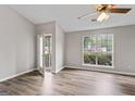 Bright bedroom with hardwood floors, fan, and backyard views through large window at 4 Bonnie Glen Ln, Hampton, GA 30228