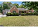 Charming one-story brick home with well-maintained lawn, mature trees, and inviting front porch at 4 Bonnie Glen Ln, Hampton, GA 30228