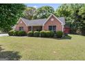 Classic brick home featuring a well-manicured lawn, tidy shrubbery, and serene, tree-lined surroundings at 4 Bonnie Glen Ln, Hampton, GA 30228