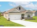 Single-story home with a two-car garage, concrete driveway, craftsman-style details, and green lawn at 1044 Claas Way, Locust Grove, GA 30248