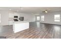Open-concept kitchen featuring stainless steel appliances, granite countertops, and wood flooring at 1044 Claas Way, Locust Grove, GA 30248