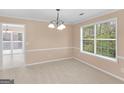 A dining room boasting natural light, a chandelier, and a view to the deck at 10018 Clearwater Trl, Jonesboro, GA 30238
