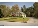 Well-maintained home featuring brick accents, lush greenery, and a driveway leading to an attached garage at 50 Clear Spring Ct, Oxford, GA 30054