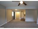 Open-concept living room with carpet, ceiling fan, laundry closet, and views of kitchen at 3410 Nw Adkins Rd, Atlanta, GA 30331