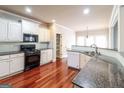 The updated kitchen features granite countertops, a tiled backsplash, and modern appliances at 1209 Richmond Rdg, Loganville, GA 30052