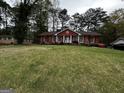 Traditional red brick home featuring a large front lawn and mature trees at 2760 The Fontainebleau Sw, Atlanta, GA 30331
