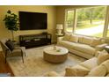 Bright living room with large windows, a neutral sofa, stylish coffee table, and modern entertainment center at 2502 Miriam Ln, Decatur, GA 30032