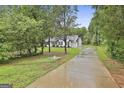 Exterior view of home with long driveway leading to the house, surrounded by mature trees and lush greenery at 2112 Highway 54, Moreland, GA 30259