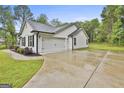 Exterior showcasing the home's side-entry two-car garage, complemented by lush landscaping and a paved driveway at 2112 Highway 54, Moreland, GA 30259