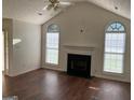 Inviting living room featuring a fireplace, vaulted ceiling, and large windows for ample natural light at 40 Canterbury Dr, Grantville, GA 30220